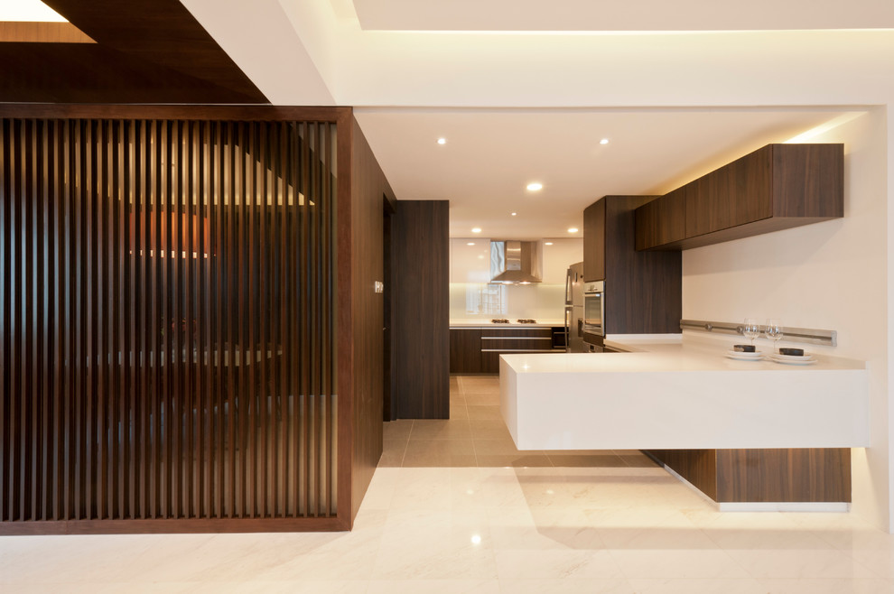 Cette photo montre une cuisine tendance en bois foncé avec un placard à porte plane et un électroménager en acier inoxydable.