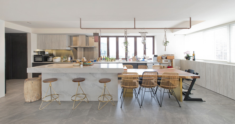 Foto di una cucina costiera con ante lisce, ante grigie, elettrodomestici bianchi, top grigio, lavello a vasca singola e pavimento grigio