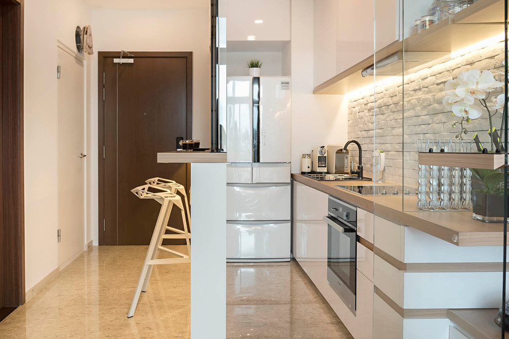 シンガポールにある小さなコンテンポラリースタイルのおしゃれな独立型キッチン (白いキッチンパネル、石タイルのキッチンパネル、シルバーの調理設備、セラミックタイルの床、アイランドなし、フラットパネル扉のキャビネット、白いキャビネット、ドロップインシンク) の写真