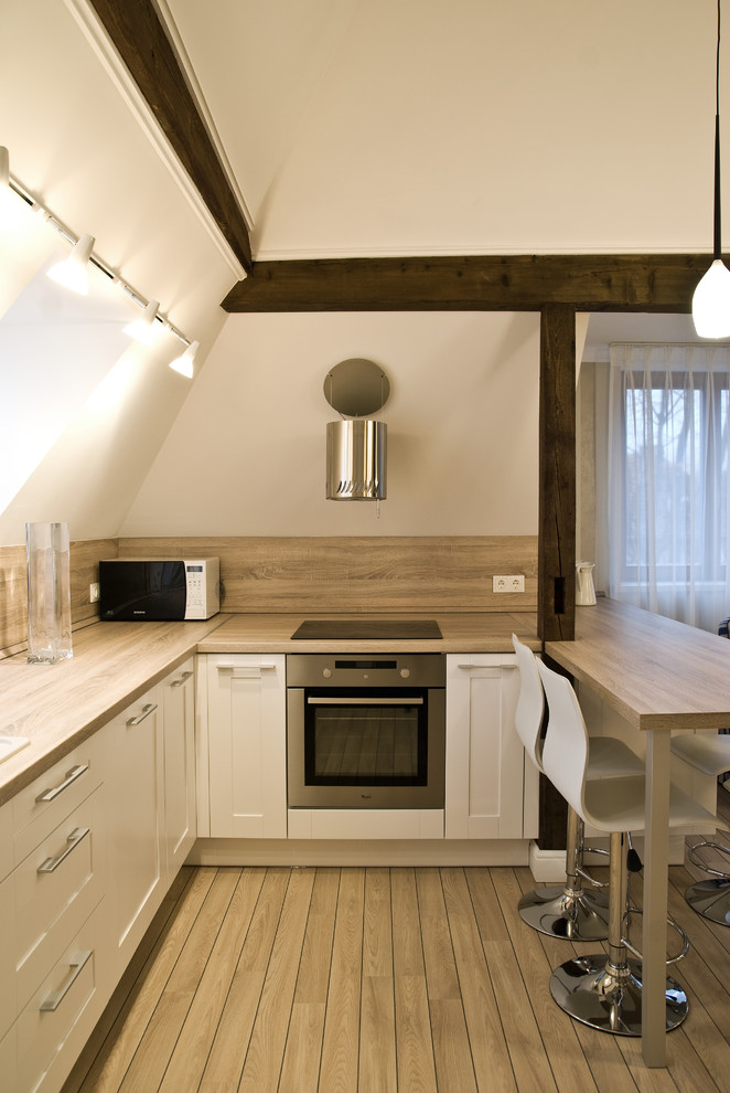 Imagen de cocina actual con puertas de armario blancas y electrodomésticos de acero inoxidable