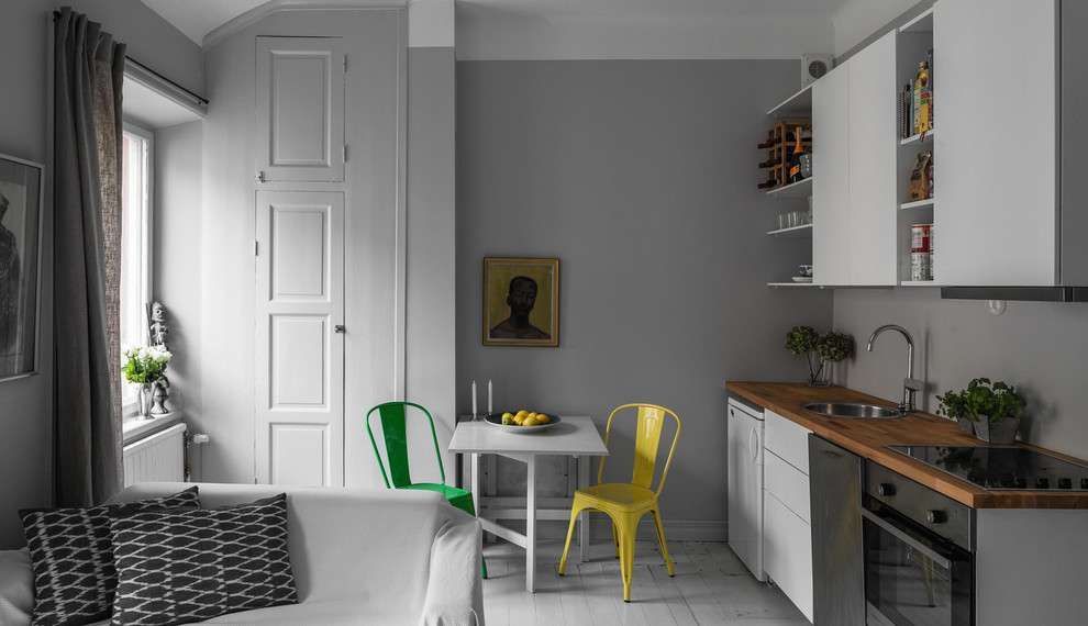 Inspiration for a small scandinavian single-wall painted wood floor open concept kitchen remodel in Stockholm with a drop-in sink, flat-panel cabinets, white cabinets, wood countertops, stainless steel appliances and no island