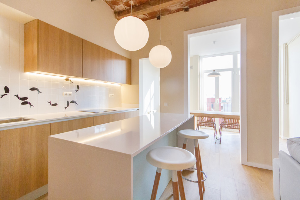 На фото: прямая кухня-гостиная среднего размера в скандинавском стиле с врезной мойкой, плоскими фасадами, фасадами цвета дерева среднего тона, паркетным полом среднего тона и полуостровом