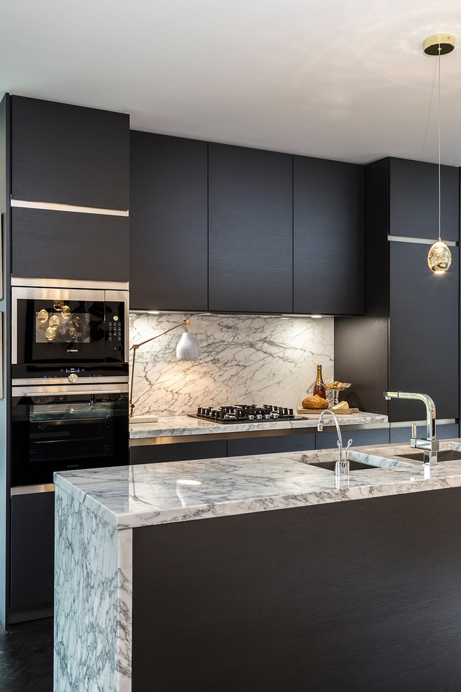 Cette photo montre une cuisine grise et noire tendance en bois foncé avec un placard à porte plane, plan de travail en marbre, une crédence en marbre, un électroménager en acier inoxydable et îlot.