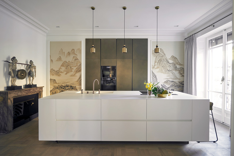 Inspiration for a large contemporary galley kitchen in Other with flat-panel cabinets, an island, white cabinets, black appliances, medium hardwood flooring, brown floors and white worktops.