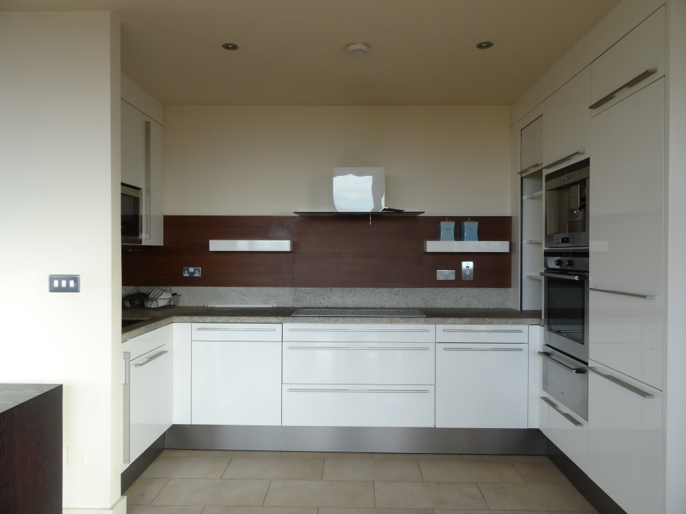 Photo of a small contemporary u-shaped open plan kitchen in Dublin with flat-panel cabinets, quartz worktops, stainless steel appliances, terrazzo flooring, multi-coloured floors and white worktops.