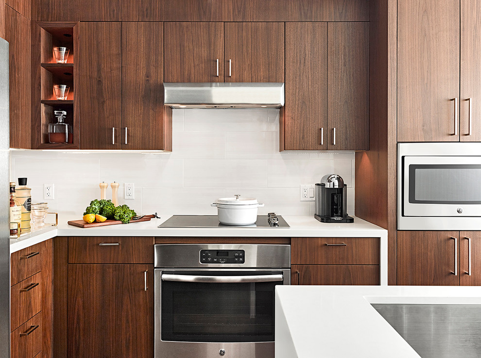 Mid-sized trendy l-shaped eat-in kitchen photo in DC Metro with flat-panel cabinets, dark wood cabinets, quartzite countertops, white backsplash, limestone backsplash, stainless steel appliances, an island and an undermount sink
