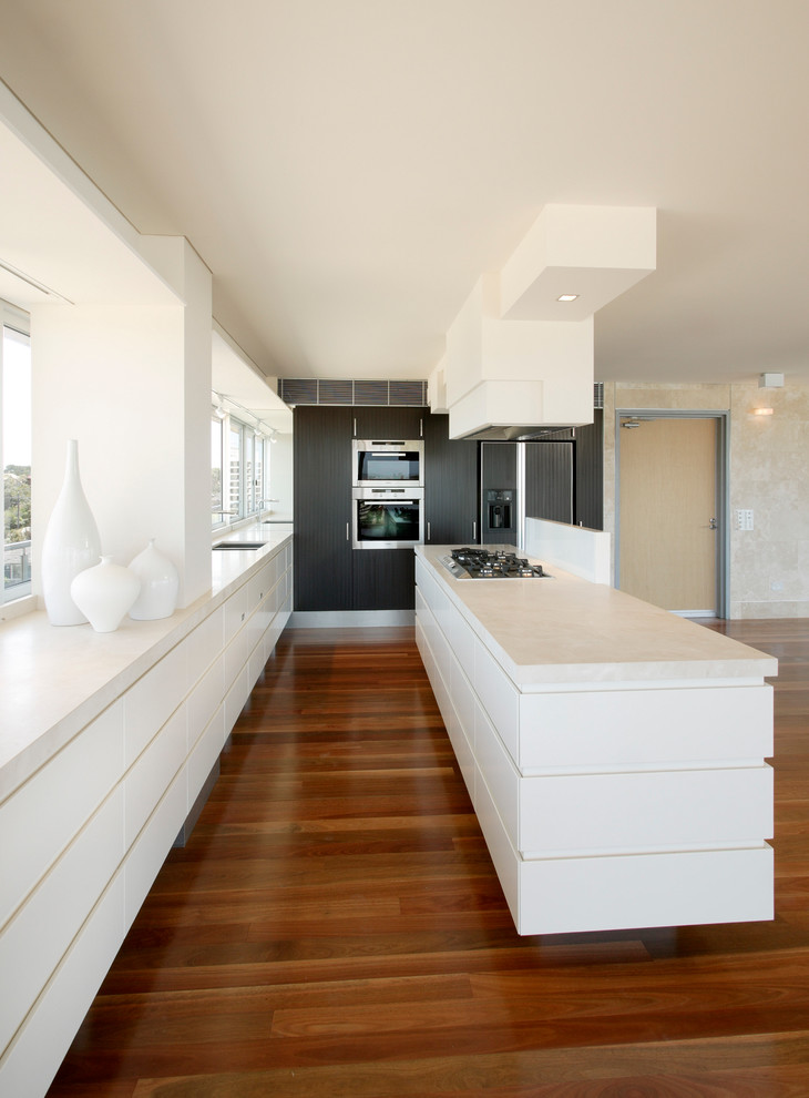 Zweizeilige, Mittelgroße Moderne Küche mit flächenbündigen Schrankfronten, weißen Schränken, Kücheninsel, Doppelwaschbecken und Küchengeräten aus Edelstahl in Sydney