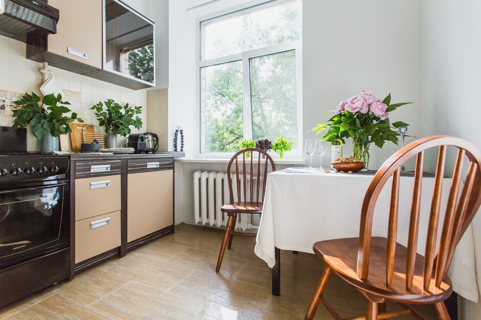 На фото: отдельная, прямая кухня в скандинавском стиле с бежевыми фасадами, белым фартуком и черной техникой без острова