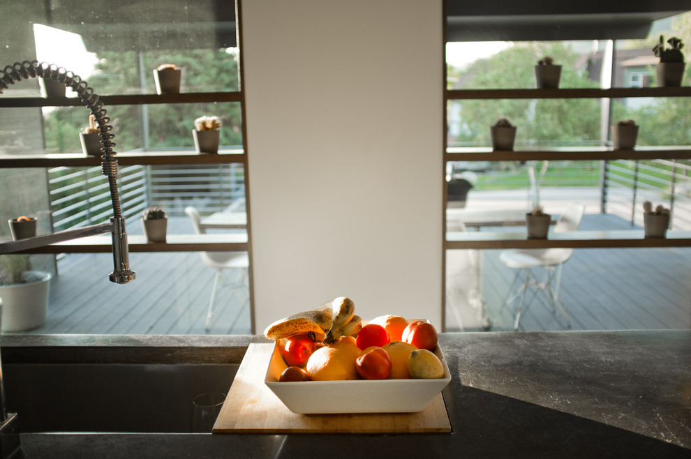 Foto di una cucina contemporanea di medie dimensioni con lavello sottopiano, ante lisce, ante in legno bruno, top in cemento, elettrodomestici in acciaio inossidabile e parquet scuro