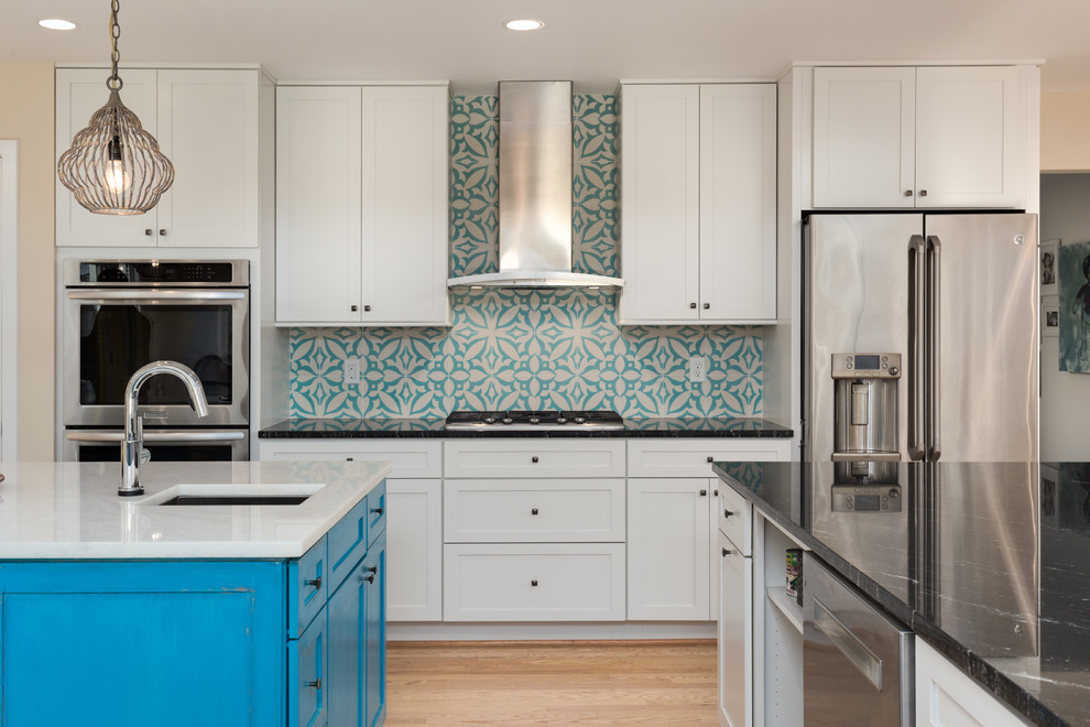 ワシントンD.C.にある高級な広いコンテンポラリースタイルのおしゃれなキッチン (エプロンフロントシンク、シェーカースタイル扉のキャビネット、白いキャビネット、御影石カウンター、青いキッチンパネル、セメントタイルのキッチンパネル、シルバーの調理設備、淡色無垢フローリング、ベージュの床、黒いキッチンカウンター) の写真