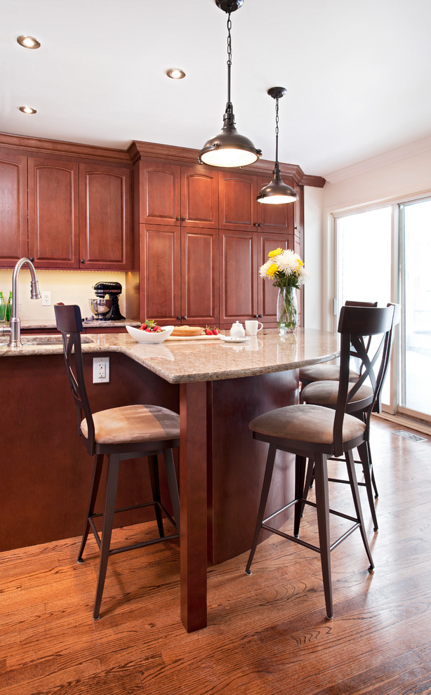 Inspiration for a large timeless l-shaped medium tone wood floor eat-in kitchen remodel in Ottawa with an undermount sink, raised-panel cabinets, red cabinets, solid surface countertops, beige backsplash, stainless steel appliances and an island