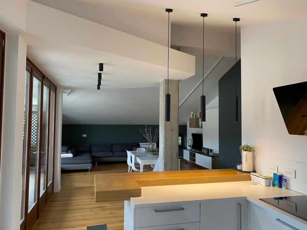 Esempio di una cucina moderna di medie dimensioni con ante lisce, ante in legno chiaro, top in legno, elettrodomestici in acciaio inossidabile, pavimento in laminato e travi a vista