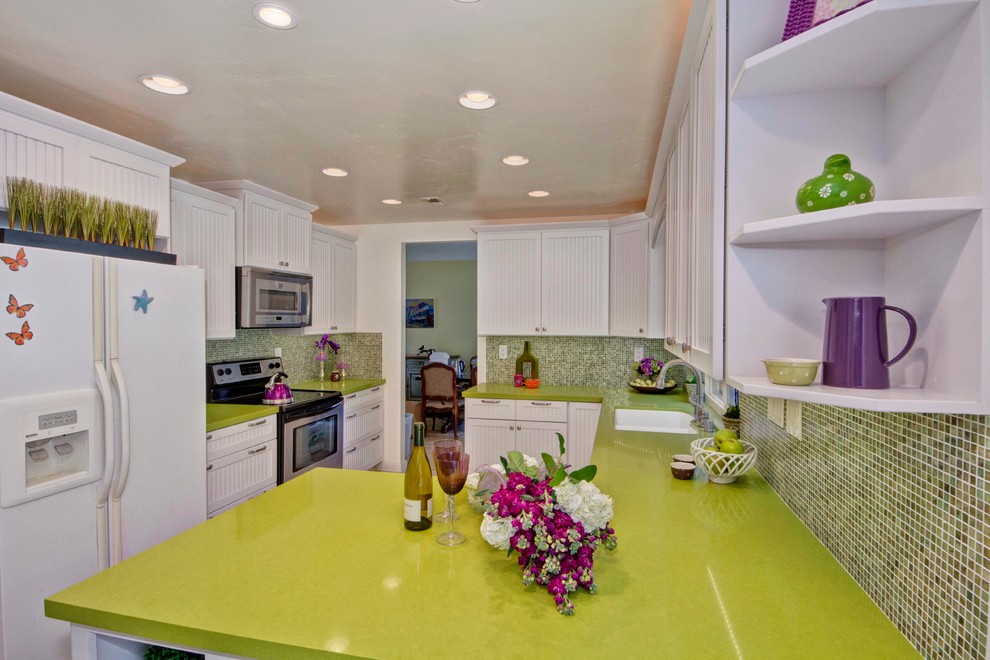 Свежая идея для дизайна: п-образная кухня в классическом стиле с белой техникой, столешницей из кварцевого агломерата, зеленым фартуком, обеденным столом, врезной мойкой, белыми фасадами и зеленой столешницей - отличное фото интерьера