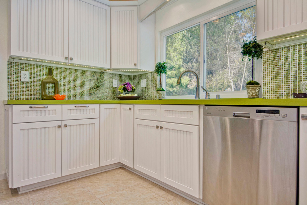 Inspiration for a timeless u-shaped eat-in kitchen remodel in San Diego with an undermount sink, beaded inset cabinets, white cabinets, quartz countertops, green backsplash and stainless steel appliances