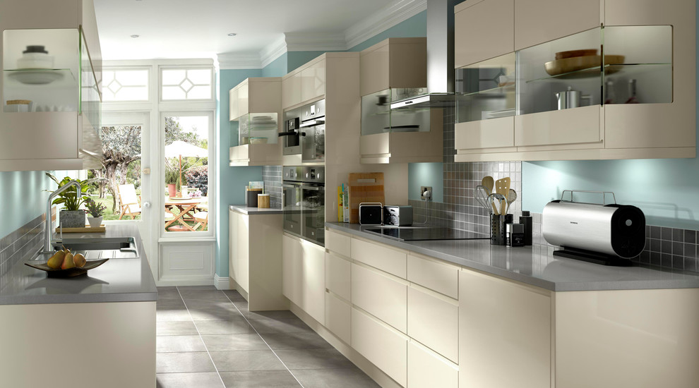 ハンプシャーにあるラグジュアリーなコンテンポラリースタイルのおしゃれなキッチン (フラットパネル扉のキャビネット、白いキャビネット、木材カウンター、グレーとクリーム色) の写真
