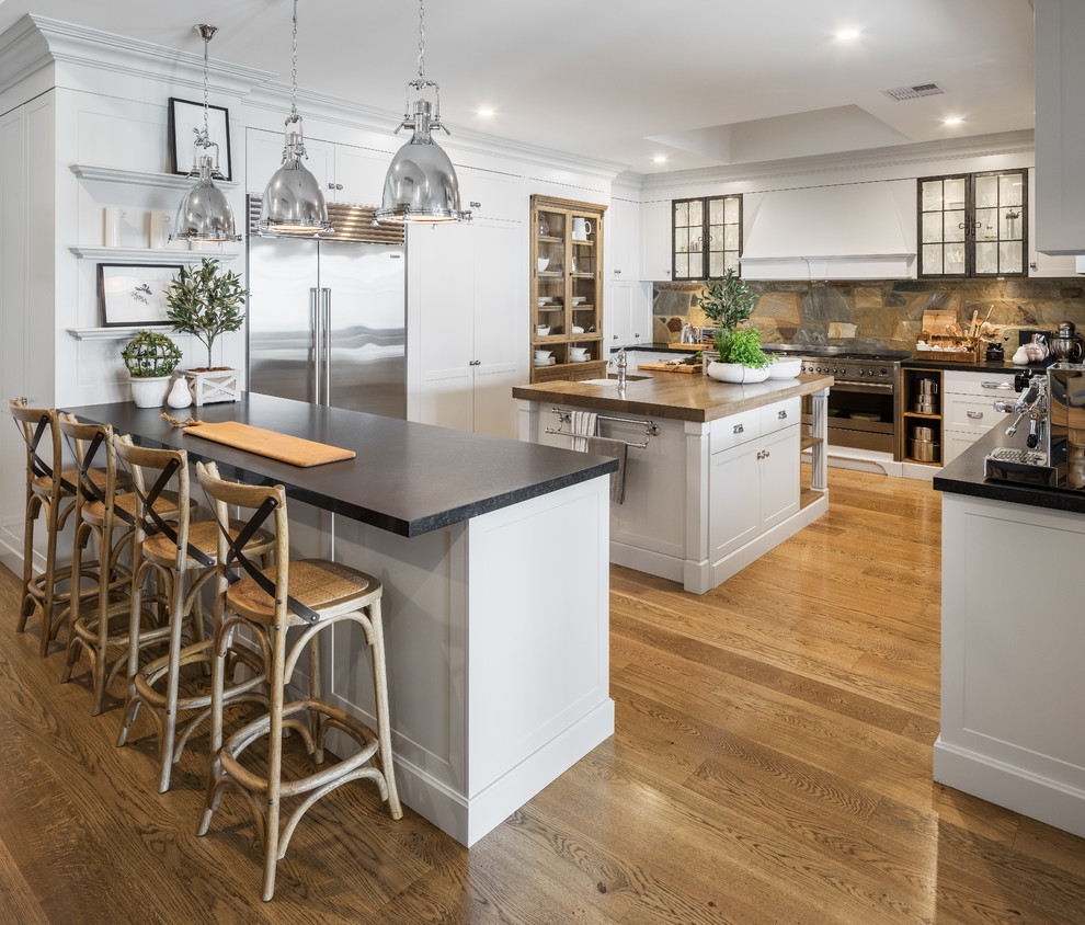 Example of a large mountain style medium tone wood floor kitchen design in Perth with an undermount sink, shaker cabinets, gray cabinets, granite countertops, brown backsplash, stainless steel appliances and an island