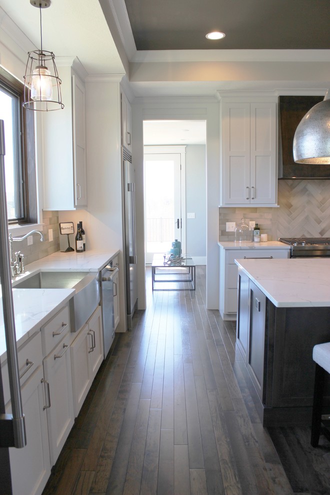 Exempel på ett stort klassiskt vit vitt kök, med en rustik diskho, släta luckor, vita skåp, bänkskiva i kvarts, grått stänkskydd, stänkskydd i keramik, rostfria vitvaror, mellanmörkt trägolv, en köksö och brunt golv