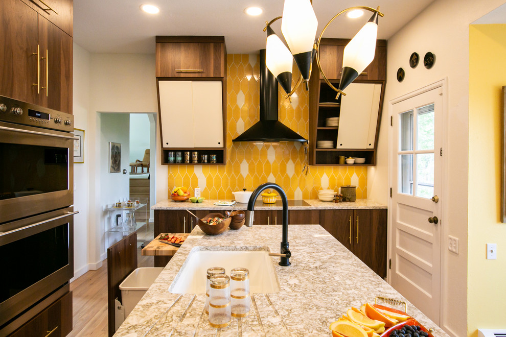 Example of a mid-sized 1960s l-shaped light wood floor and brown floor eat-in kitchen design in Denver with an undermount sink, flat-panel cabinets, medium tone wood cabinets, quartz countertops, yellow backsplash, ceramic backsplash, stainless steel appliances, an island and multicolored countertops