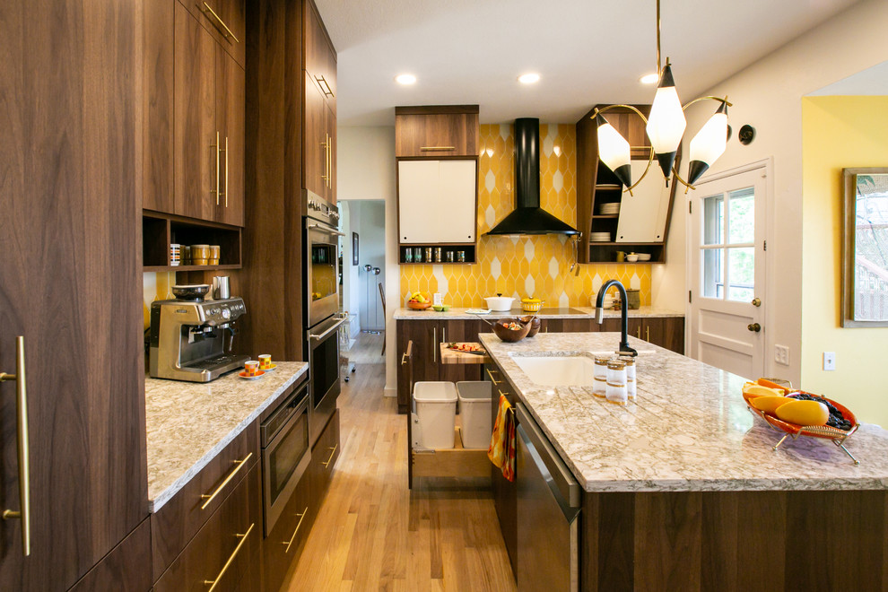 Retro inredning av ett mellanstort flerfärgad flerfärgat kök, med en undermonterad diskho, släta luckor, skåp i mellenmörkt trä, bänkskiva i kvarts, gult stänkskydd, stänkskydd i keramik, rostfria vitvaror, ljust trägolv, en köksö och brunt golv