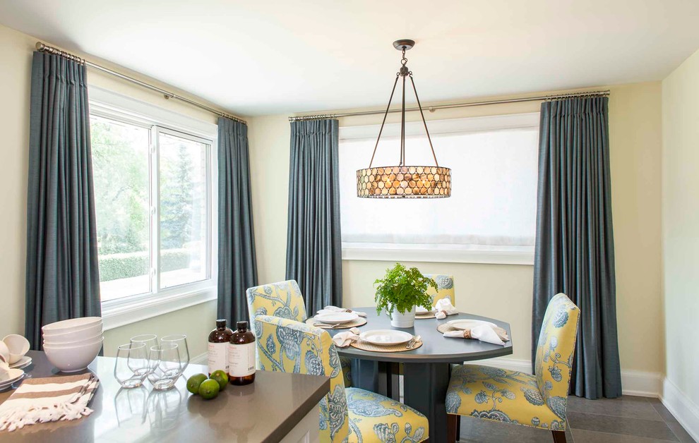 Immagine di una sala da pranzo aperta verso la cucina design di medie dimensioni con pareti gialle, pavimento in pietra calcarea e pavimento grigio