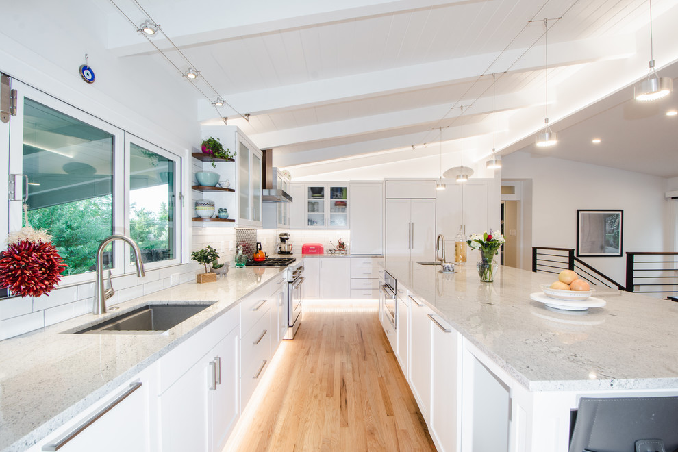 Example of a large 1950s l-shaped light wood floor eat-in kitchen design in Denver with an undermount sink, shaker cabinets, white cabinets, granite countertops, green backsplash, mosaic tile backsplash, paneled appliances, an island and gray countertops