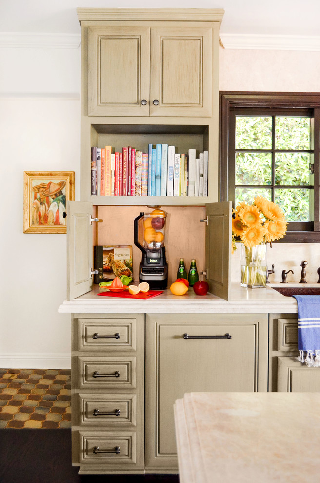 Large tuscan l-shaped dark wood floor and brown floor open concept kitchen photo in Los Angeles with an undermount sink, raised-panel cabinets, green cabinets, quartzite countertops, beige backsplash, stone slab backsplash, paneled appliances, an island and beige countertops