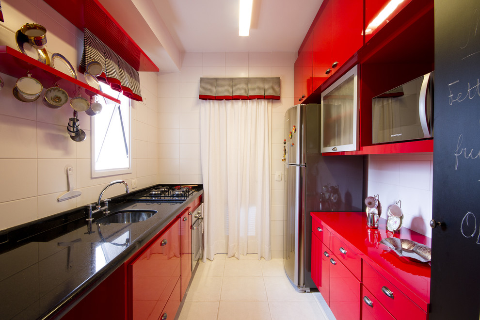 Diseño de cocina ecléctica con electrodomésticos de acero inoxidable y encimeras rojas