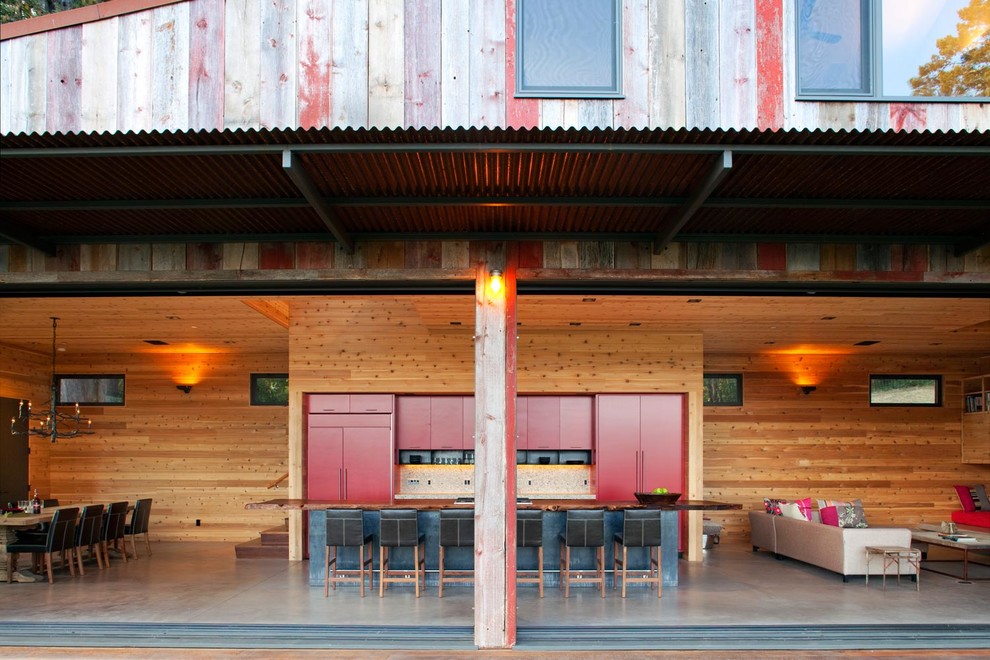 Offene Moderne Küche mit flächenbündigen Schrankfronten, roten Schränken, Arbeitsplatte aus Holz, Elektrogeräten mit Frontblende, Betonboden und Kücheninsel in San Francisco