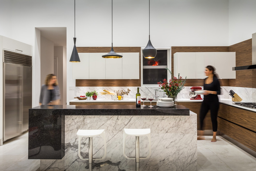 Moderne Küche in L-Form mit flächenbündigen Schrankfronten, hellbraunen Holzschränken, Küchenrückwand in Weiß und Kücheninsel in Miami