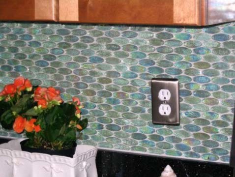 На фото: п-образная кухня среднего размера в современном стиле с обеденным столом, фасадами цвета дерева среднего тона, гранитной столешницей, синим фартуком, фартуком из стеклянной плитки и черной техникой без острова с