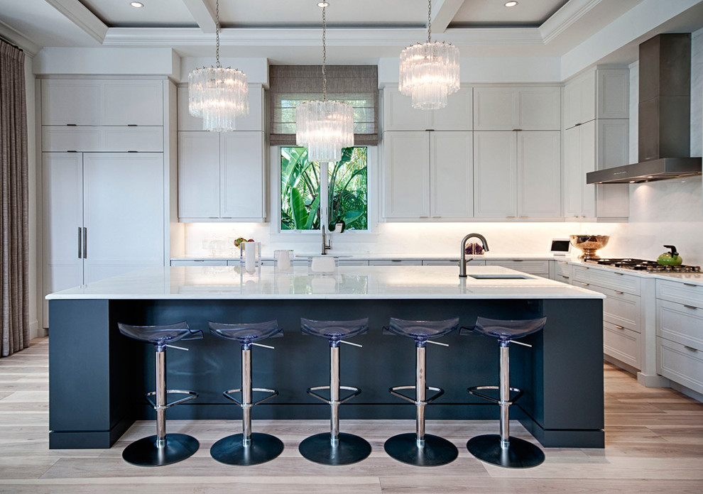Photo of a contemporary l-shaped kitchen in Miami with recessed-panel cabinets, grey cabinets, white splashback and integrated appliances.