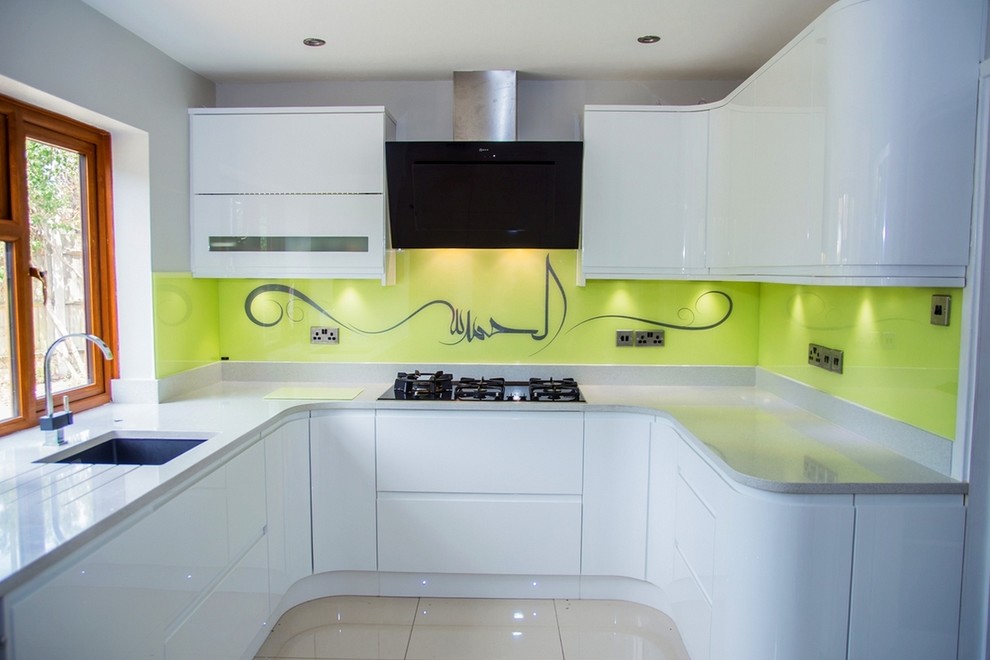 Exempel på ett modernt kök, med gult stänkskydd och glaspanel som stänkskydd