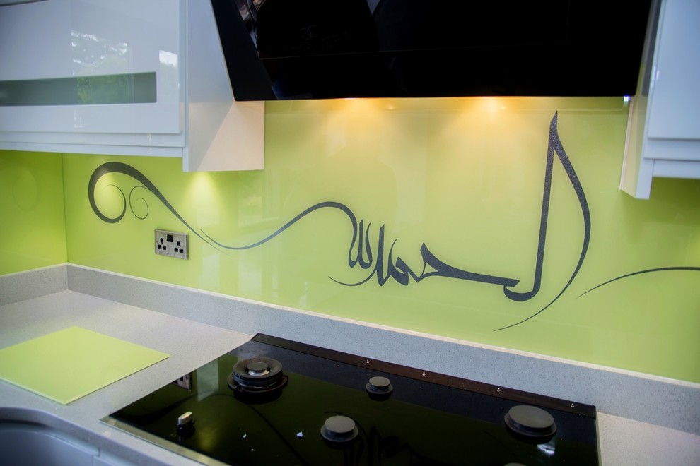 Idée de décoration pour une cuisine design avec une crédence jaune et une crédence en feuille de verre.