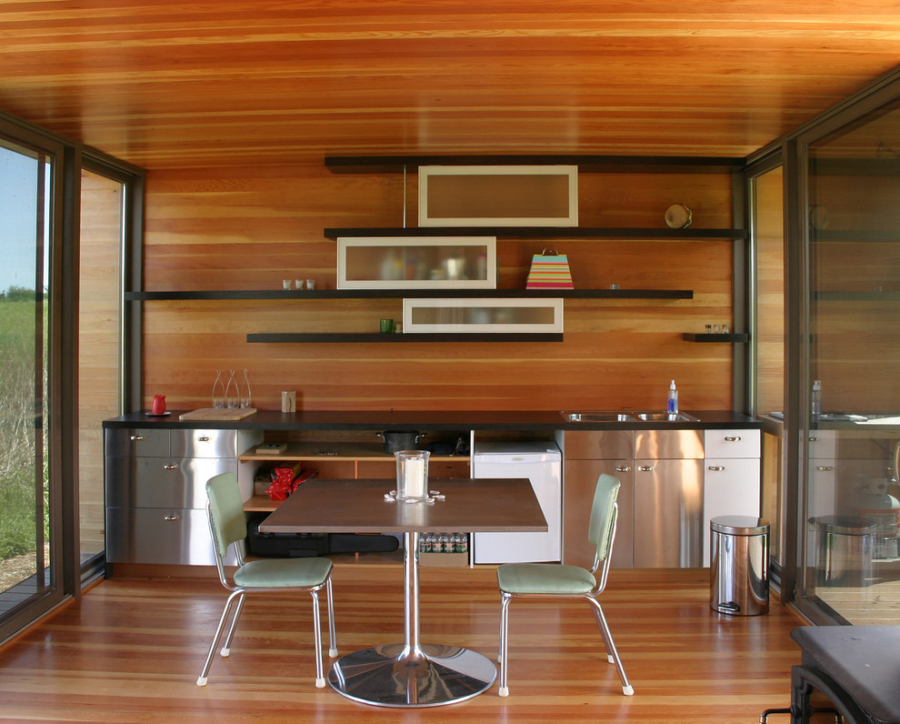 Источник вдохновения для домашнего уюта: прямая кухня в стиле модернизм с обеденным столом, плоскими фасадами, фасадами из нержавеющей стали и шторами на окнах
