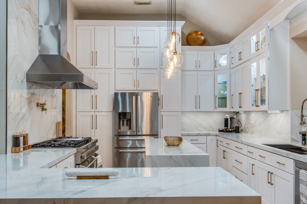 Inspiration for a large modern l-shaped kitchen/diner in Houston with a submerged sink, shaker cabinets, white cabinets, composite countertops, white splashback, porcelain splashback, stainless steel appliances, marble flooring, an island, beige floors and white worktops.