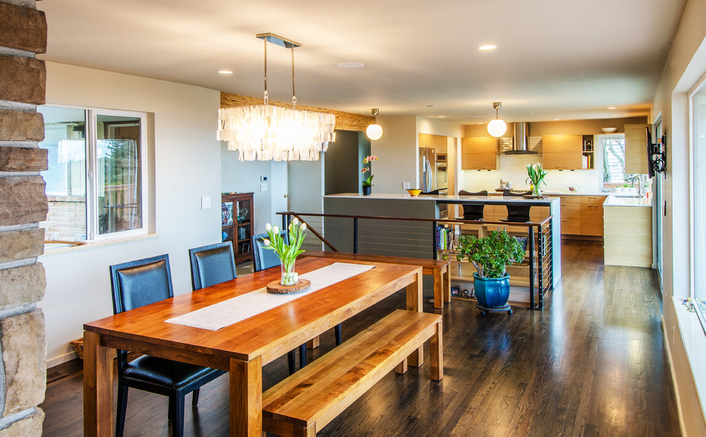 Imagen de cocina rectangular moderna con armarios con paneles lisos, puertas de armario de madera clara, salpicadero blanco y electrodomésticos de acero inoxidable