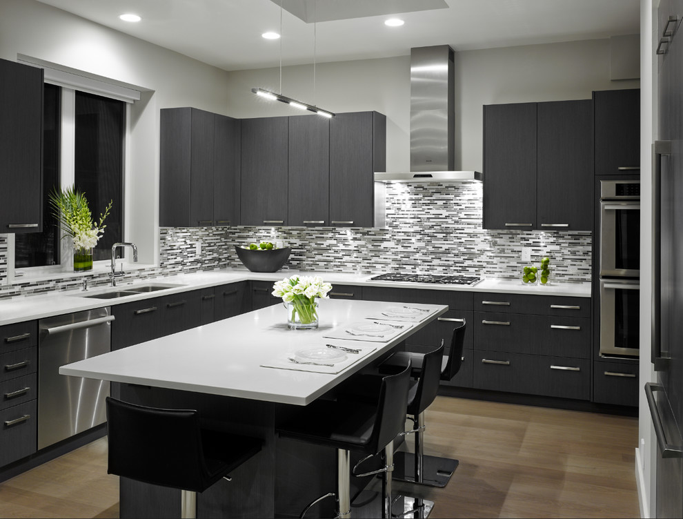 Moderne Küche in L-Form mit flächenbündigen Schrankfronten, bunter Rückwand, Küchengeräten aus Edelstahl und Kücheninsel in Vancouver