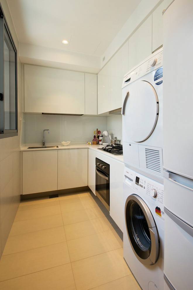 Idée de décoration pour une petite cuisine design en L fermée avec machine à laver.