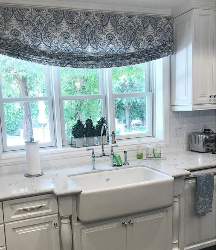 Immagine di una cucina di medie dimensioni con lavello integrato, ante lisce, ante bianche, top in marmo, paraspruzzi bianco, pavimento marrone e top bianco