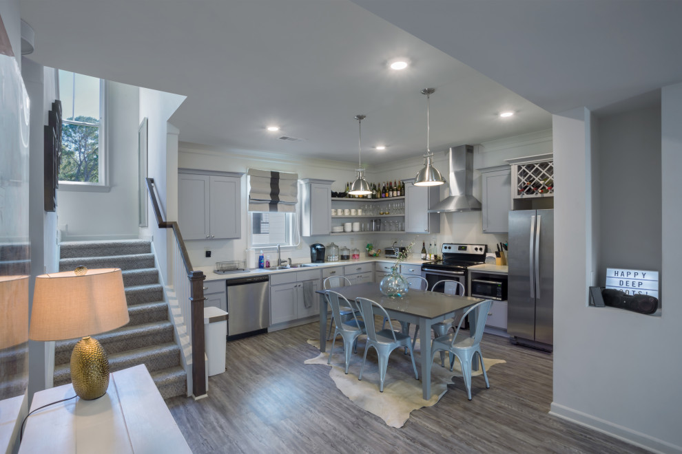 Example of a mid-sized farmhouse l-shaped vinyl floor and brown floor eat-in kitchen design in Atlanta with a double-bowl sink, shaker cabinets, gray cabinets, granite countertops, white backsplash, stone slab backsplash, stainless steel appliances, an island and white countertops