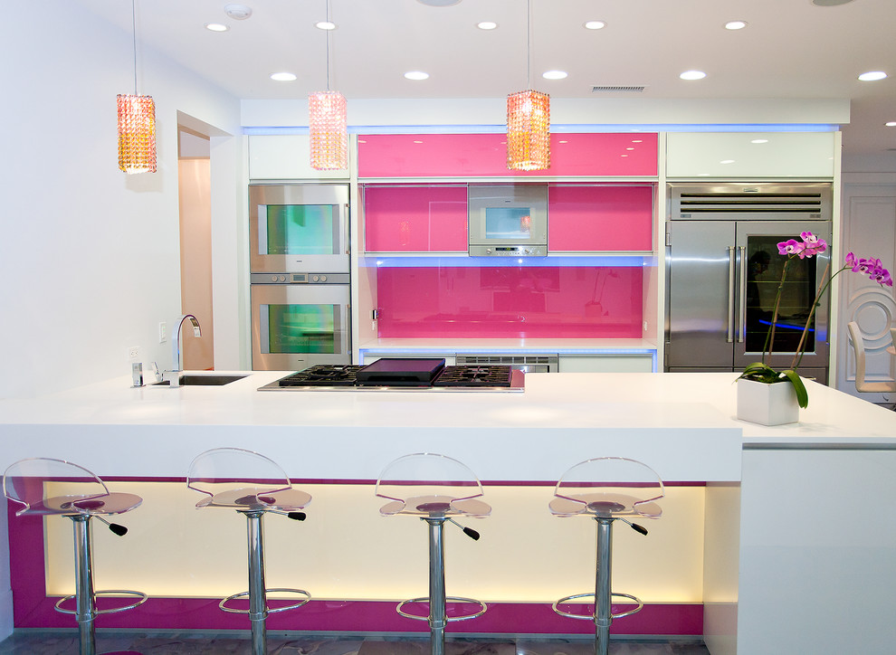 This is an example of a contemporary kitchen in Los Angeles with stainless steel appliances, a single-bowl sink and pink splashback.