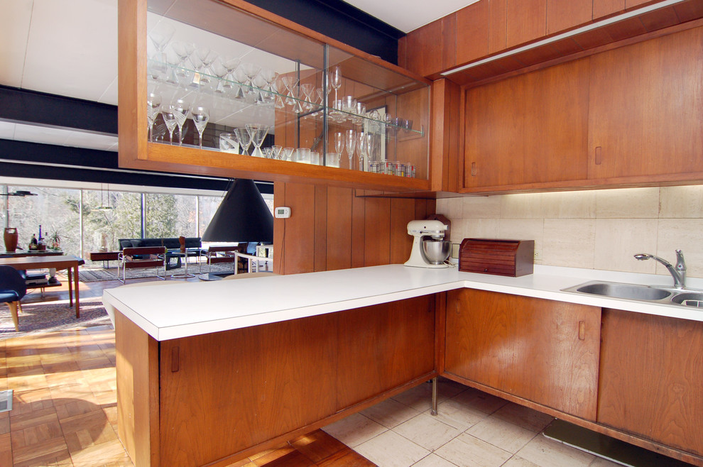 На фото: кухня-гостиная в стиле ретро с накладной мойкой, плоскими фасадами, фасадами цвета дерева среднего тона, столешницей из ламината и бежевым фартуком