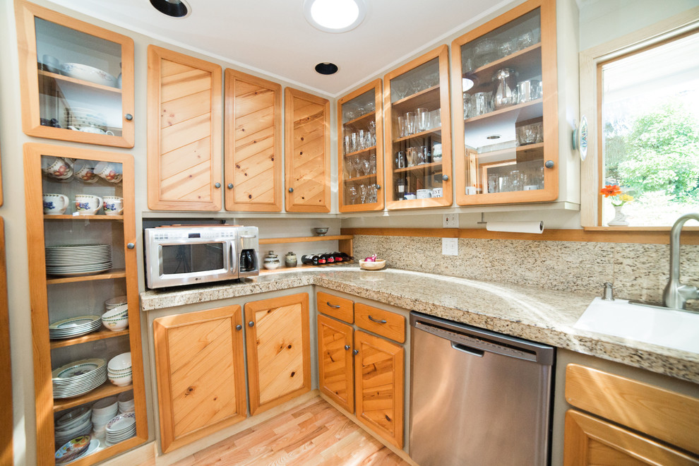 This is an example of a medium sized classic u-shaped enclosed kitchen in Seattle with a single-bowl sink, recessed-panel cabinets, medium wood cabinets, granite worktops, beige splashback, stone tiled splashback, stainless steel appliances and medium hardwood flooring.