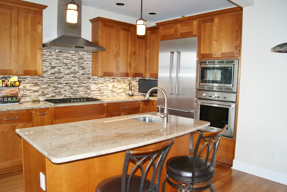 Mittelgroße Urige Küche mit flächenbündigen Schrankfronten, hellbraunen Holzschränken, bunter Rückwand, Rückwand aus Stäbchenfliesen, braunem Holzboden und Kücheninsel in Seattle