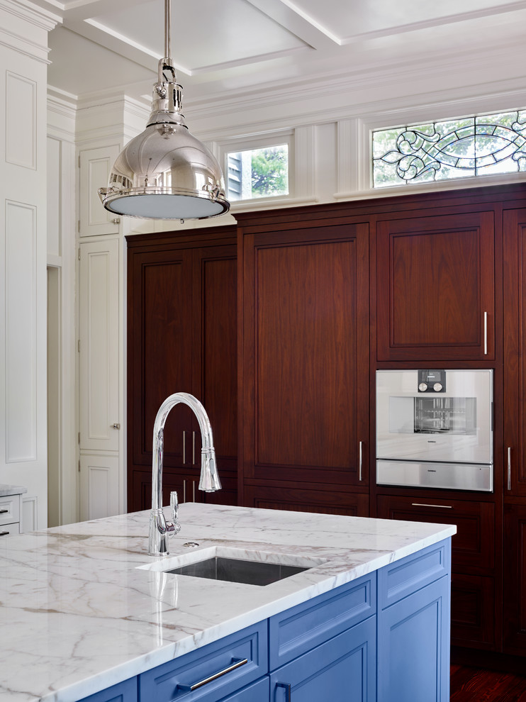 Inspiration for a large classic kitchen/diner in Atlanta with recessed-panel cabinets, white splashback, ceramic splashback, stainless steel appliances, medium hardwood flooring and an island.