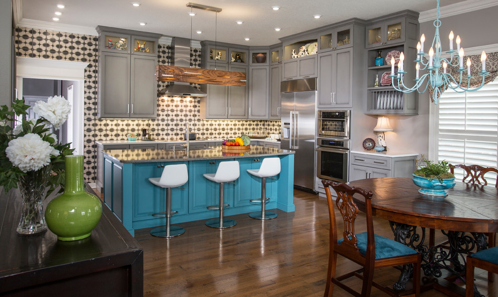 Inspiration for an eclectic l-shaped medium tone wood floor and brown floor eat-in kitchen remodel in Other with recessed-panel cabinets, turquoise cabinets, multicolored backsplash, stainless steel appliances, an island and gray countertops