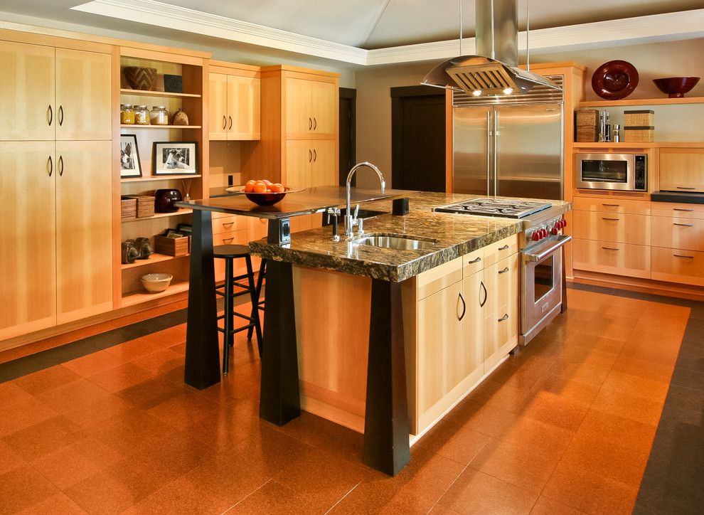 ポートランドにあるモダンスタイルのおしゃれなキッチン (シルバーの調理設備、フラットパネル扉のキャビネット、淡色木目調キャビネット、オレンジの床) の写真