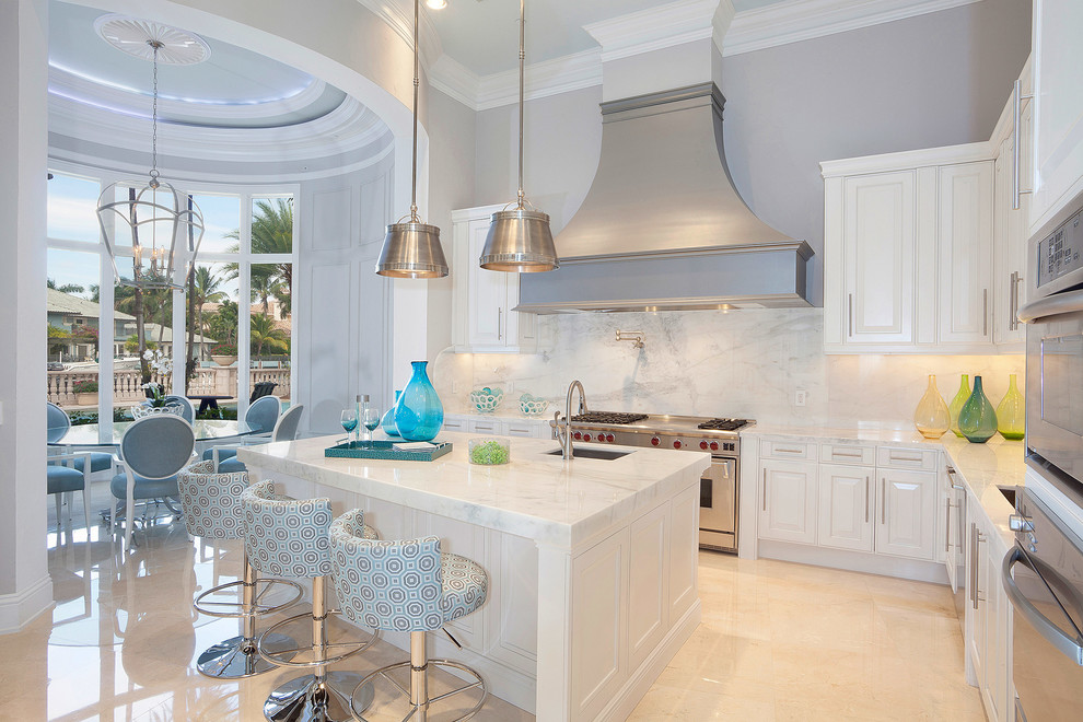 Klassische Wohnküche mit Unterbauwaschbecken, profilierten Schrankfronten, weißen Schränken, Küchenrückwand in Weiß und Küchengeräten aus Edelstahl in Miami