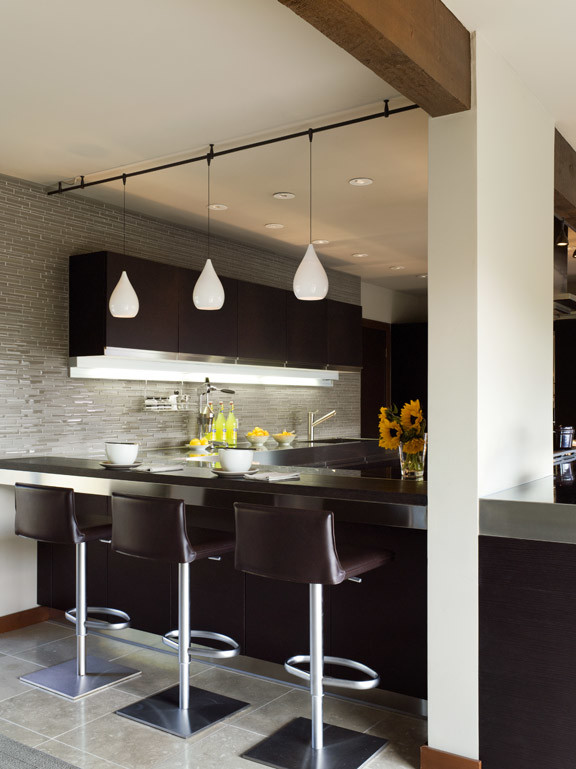 Eat-in kitchen - large modern u-shaped eat-in kitchen idea in San Francisco with an integrated sink, flat-panel cabinets, dark wood cabinets, stainless steel countertops, paneled appliances and a peninsula