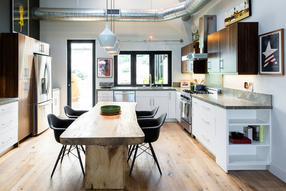 Foto på ett litet funkis kök, med en undermonterad diskho, släta luckor, skåp i mörkt trä, granitbänkskiva, grönt stänkskydd, rostfria vitvaror, mellanmörkt trägolv och beiget golv